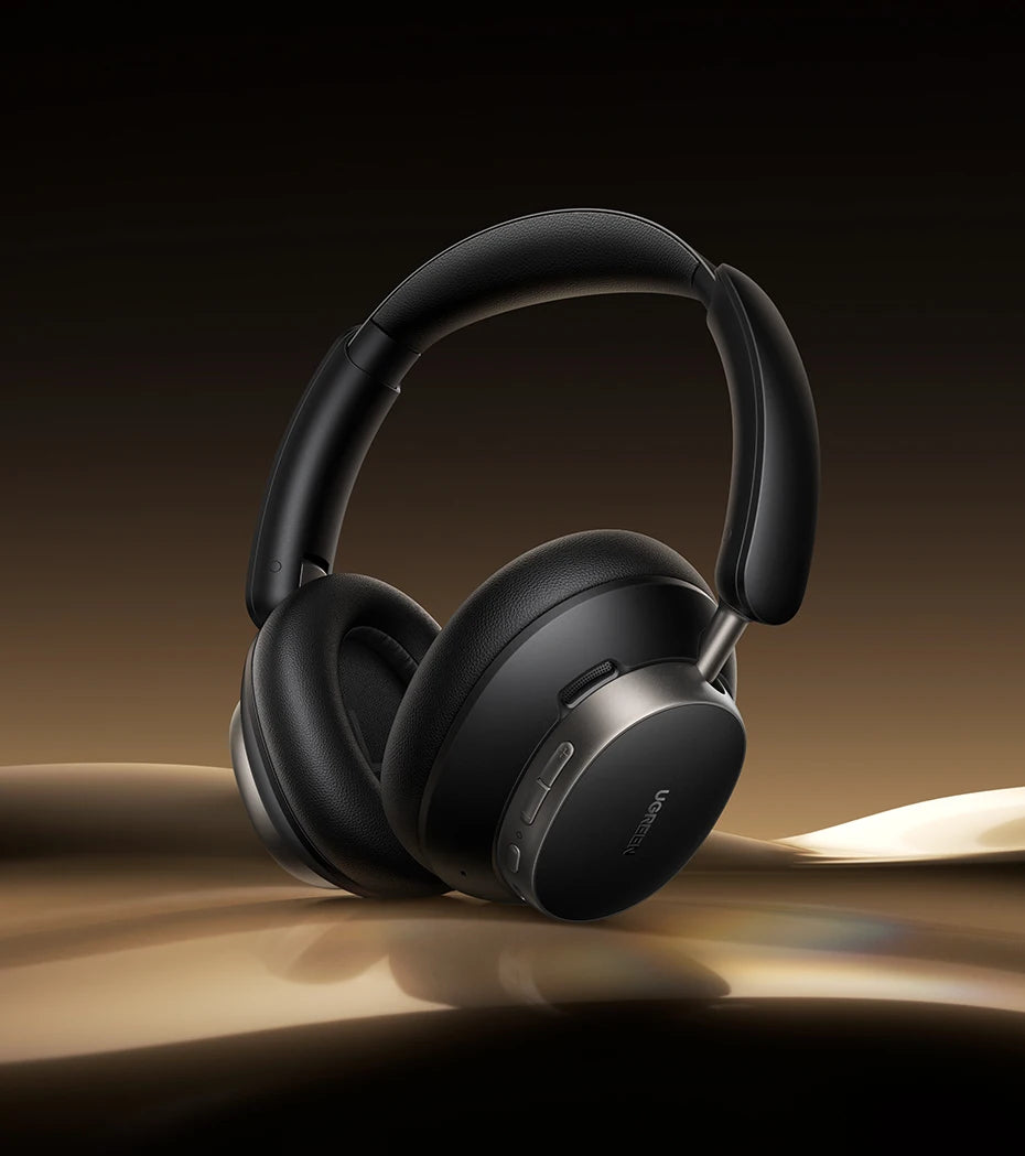 Black headphones on a reflective surface with a dark background