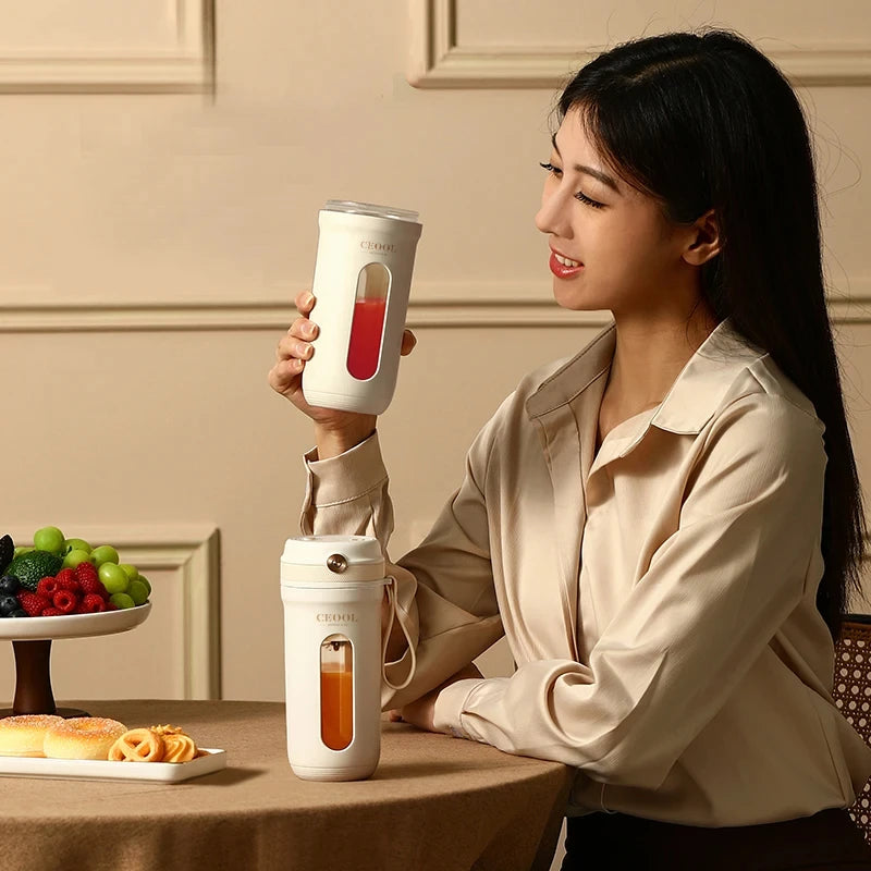 Woman holding a white tumbler with a clear lid, sitting at a table with fruits and pastries.