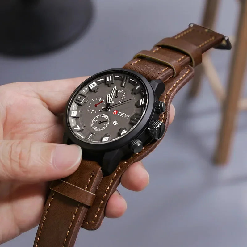 Hand holding a brown leather watch with a detailed face, brand 'KTEVI' visible.