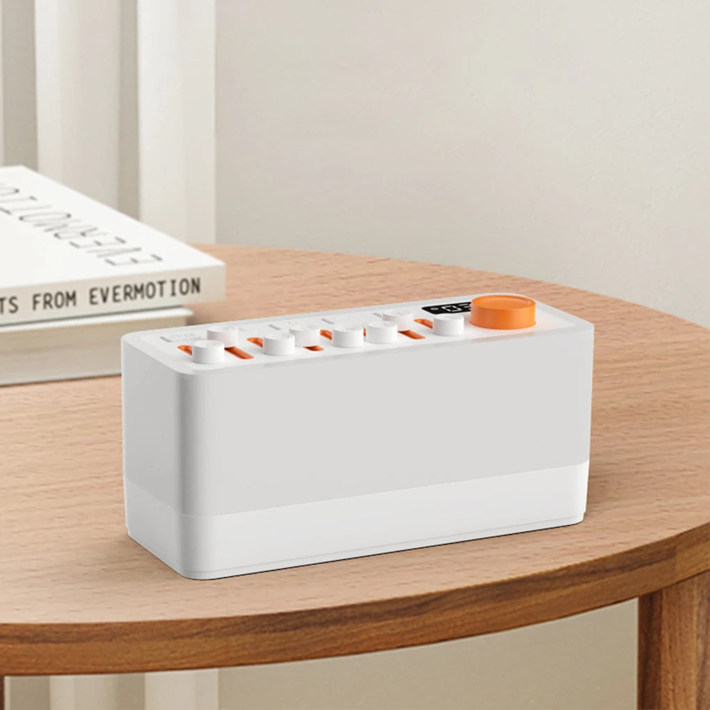 White electronic device with orange accents on a wooden table
